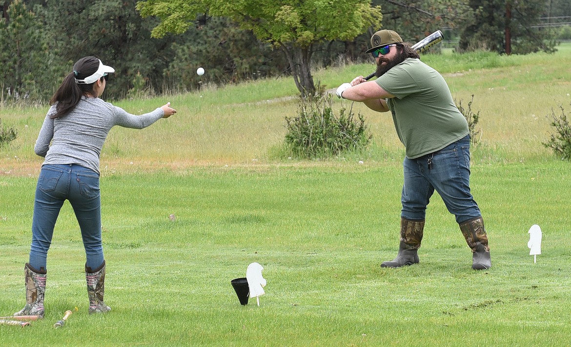 AT RIGHT, Plains&#146; Tim McKevitt asks his wife, Sarah, to pitch the golf ball to him for the infamous Hole #5 baseball bat drive.