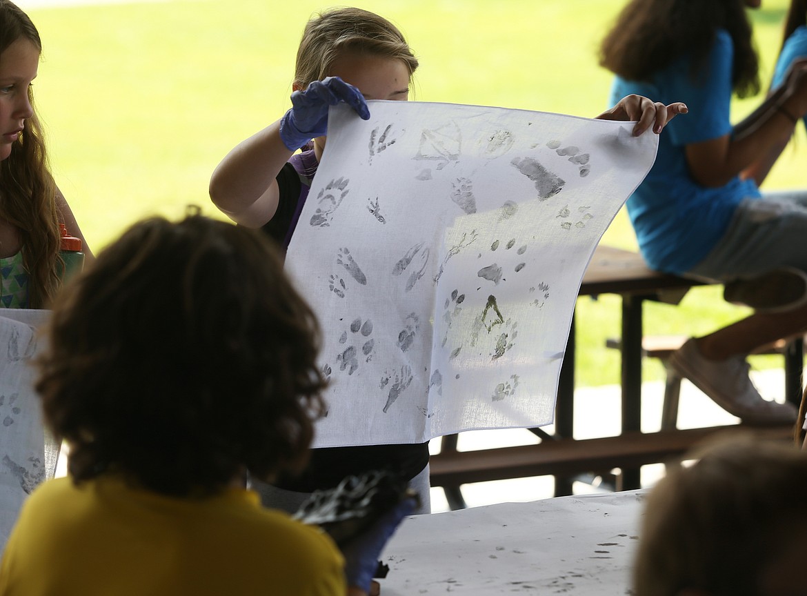 Skyway Elementary School fifth grade student Harmoni Halloway looks at her bandana with different animal track prints during Thursday's Water Festival at McEuen Park. (LOREN BENOIT/Press)