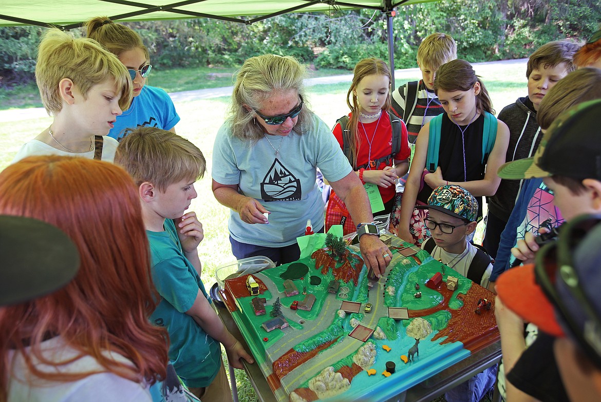 Fernan STEM Academy fifth-grade students watch as Kristi Milan, with Kootenai Environmental Alliance, drops dye onto a watershed to resemble oil during Thursday's Water Festival at McEuen Park. (LOREN BENOIT/Press)