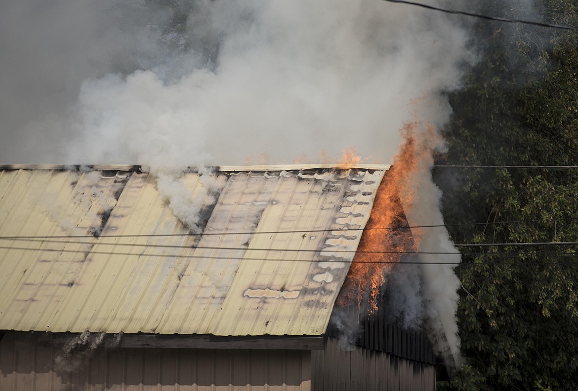 Flames rise from the attic of a shed fire, Wednesday around noon by Wisconsin and East 6th Street in Libby. (Luke Hollister/The Western News)