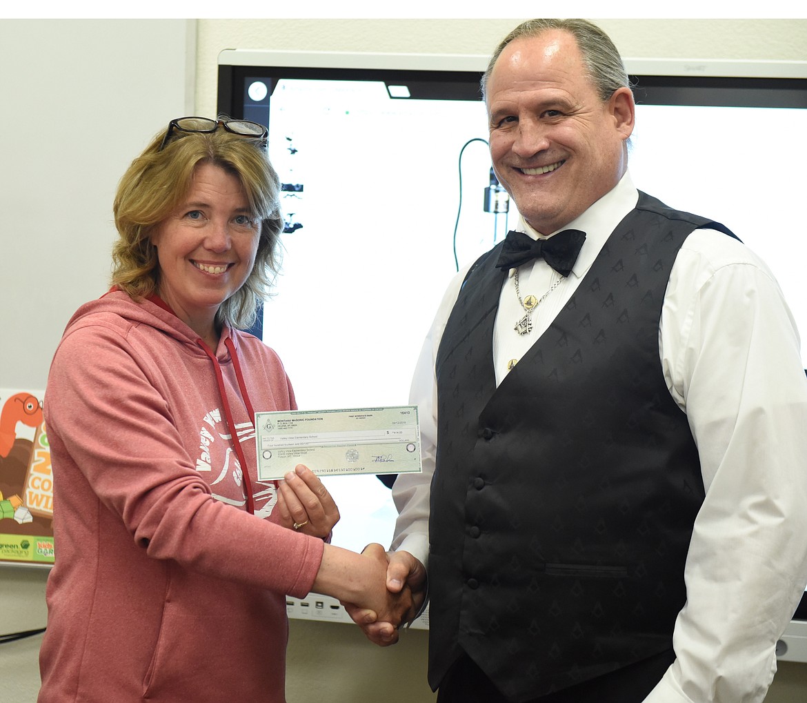 KIM BOWMAN, district officer for Masons, presented a $414 check to Carol Madden, the math, science and technology teacher at Valley View Elementary School. The grant money will pay for a new miscroscope that can be interfaced with a laptop computer. (Joe Sova photos/Lake County Leader)