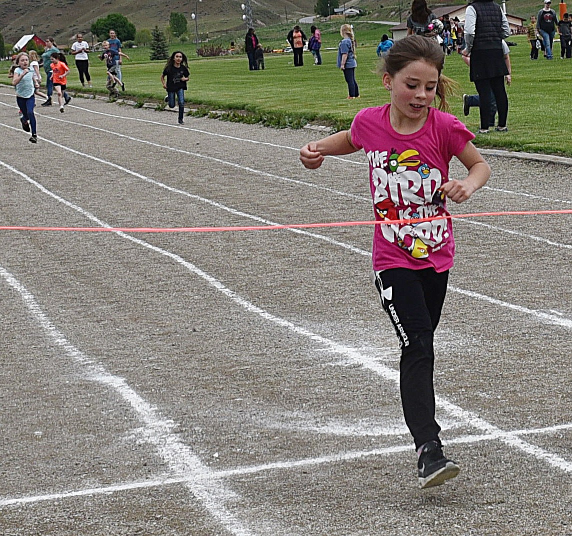 EMILY JOSEPHSON, a second grader, crosses the finish line first during the 200-meter dash.