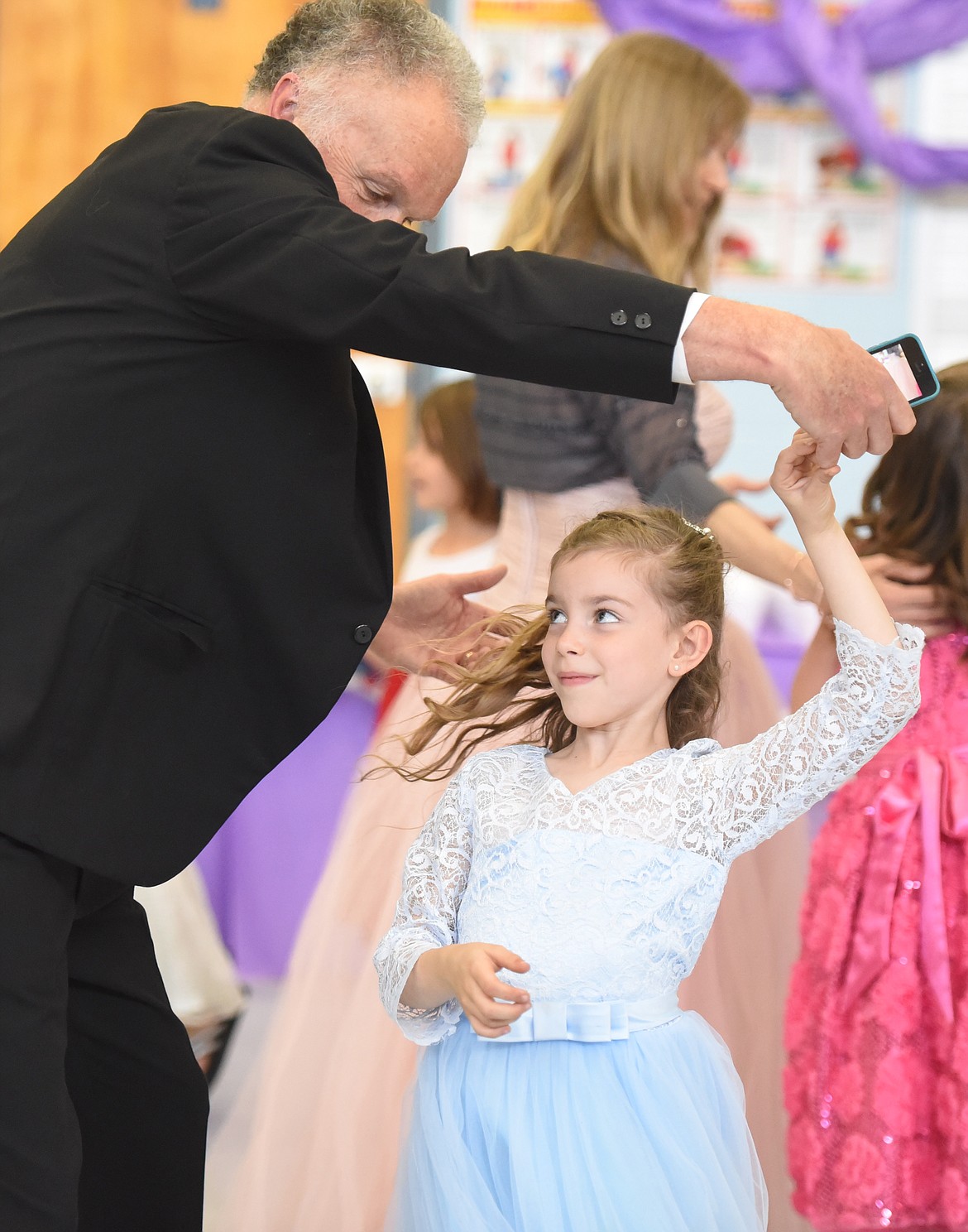 ABIGAIL DYCK gets a quick twirl from Doug Crosby during &#147;Cinderella&#146;s Ball.&#148; Doug was a favorite of many of the first-grade girls at the event.