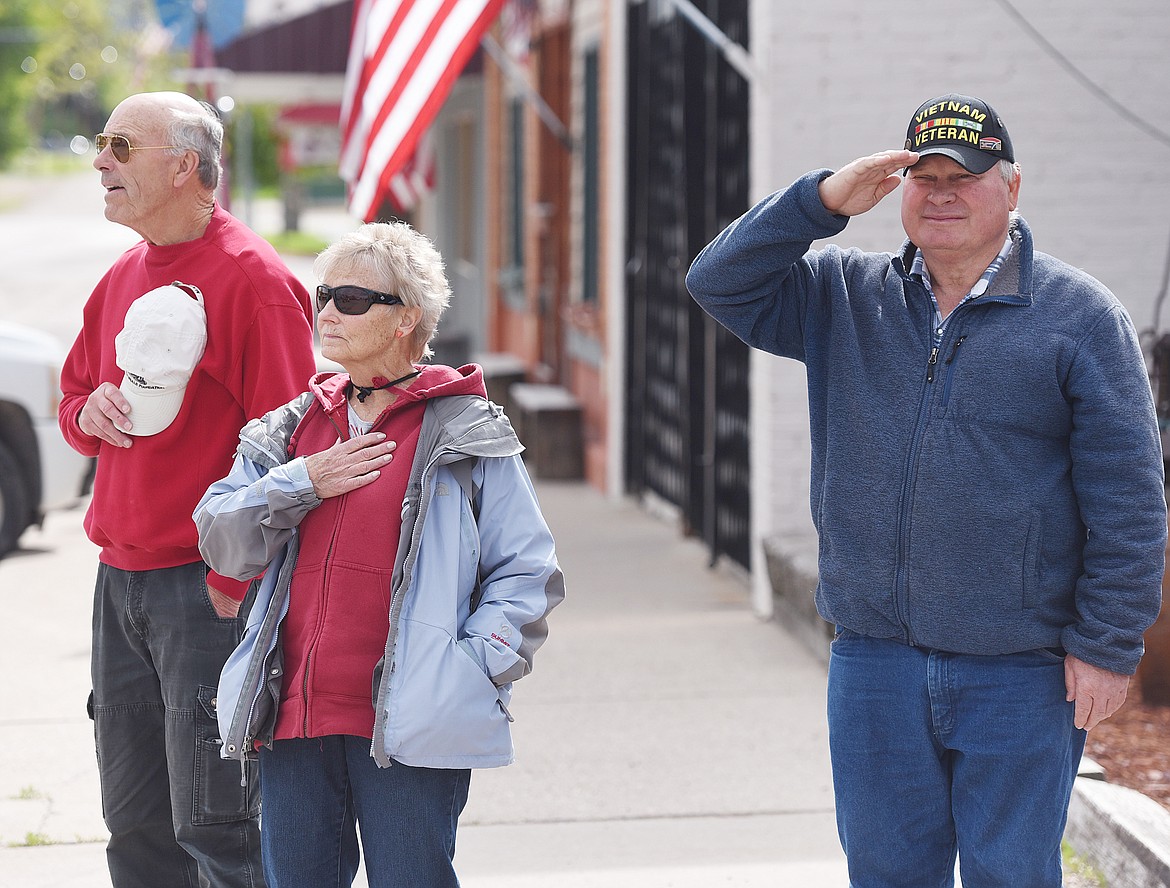 FROM LEFT, Nels and Kathy Jensen, and Gary Hoffer salute as they watch the American Legion Memorial Day parade in Ronan. Nels is a National Guard veteran, and Gary is a veteran of the Vietnam War.