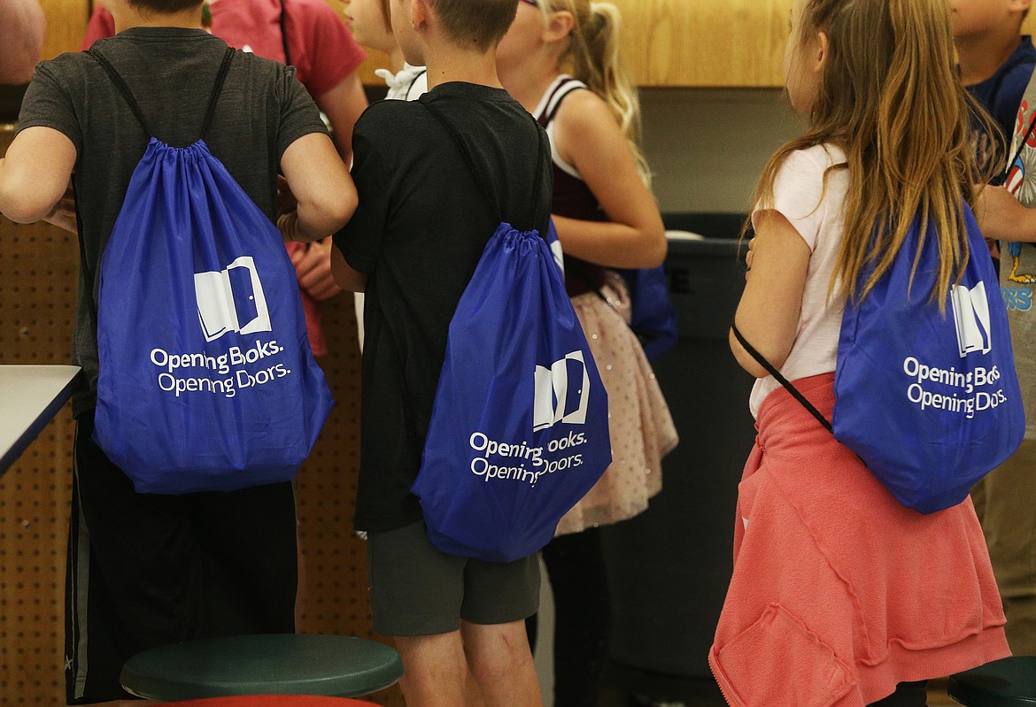 First- and second-grade students gather with their Opening Books, Opening Doors backpacks during distribution day Wednesday at Dalton Elementary School. (LOREN BENOIT/Press)