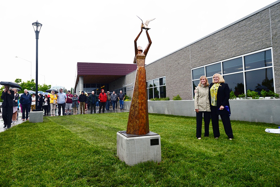 Beth Lendrum, right, and artist Jeannine Young stand aside Young&#146;s sculpture titled &#147;Letting Go&#148; that was unveiled before a ribbon-cutting ceremony outside Flathead Valley Community College&#146;s new Broussard Family Library and Learning Commons on Thursday. (Casey Kreider/Daily Inter Lake)