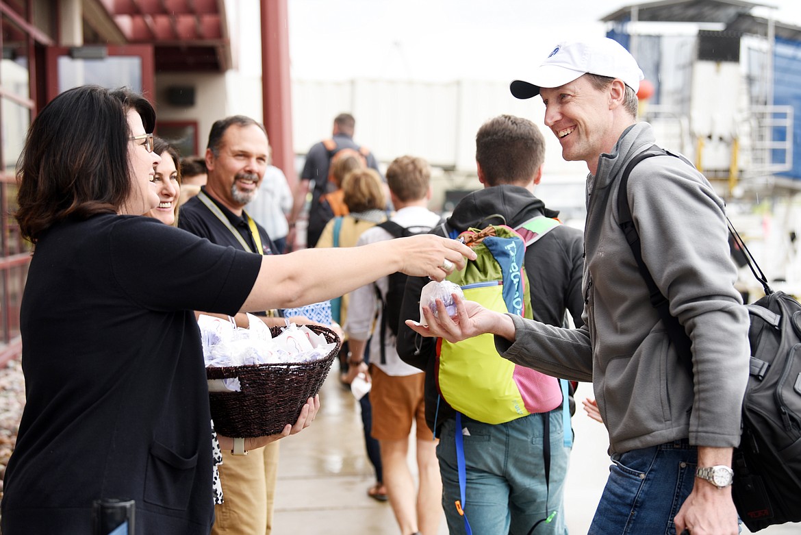 Julie Gates, office coordinator for Glacier Park International Airport, and Rob Ratkowski, airport director, hand out welcome bags to passengers of the American Airlines inaugural flight from Dallas/Fort Worth to Glacier Park International Airport on Thursday, June 6. (Brenda Ahearn/Daily Inter Lake)