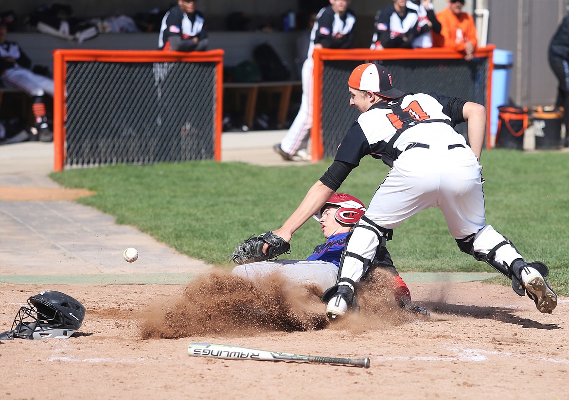 Coeur d&#146;Alene baserunner Quinton Bunch scores before Post Falls catcher Derek Pearse can corral the throw in a doubleheader in late April at Post Falls High School.