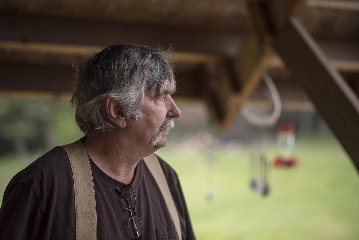 Martin Dunbar stands on his front porch, looking out to the Panoramic View Estates subdivision road, from where dust normally floats down, May 20. &#147;All summer long we get dirt poured on us,&#148; he said. (Luke Hollister/The Western News)