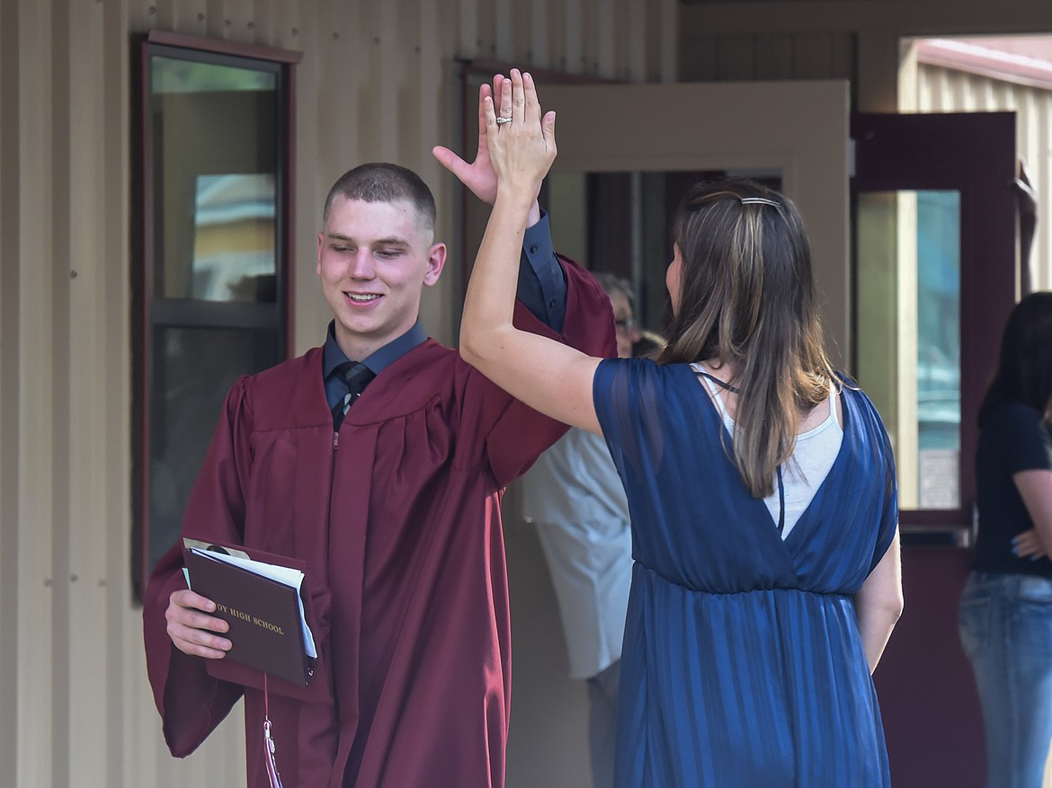 Troy High School&#146;s Michael Beers high-fives Troy High School Principal Christina Schertel after Troy&#146;s graduation Saturday. (Ben Kibbey/The Western News)