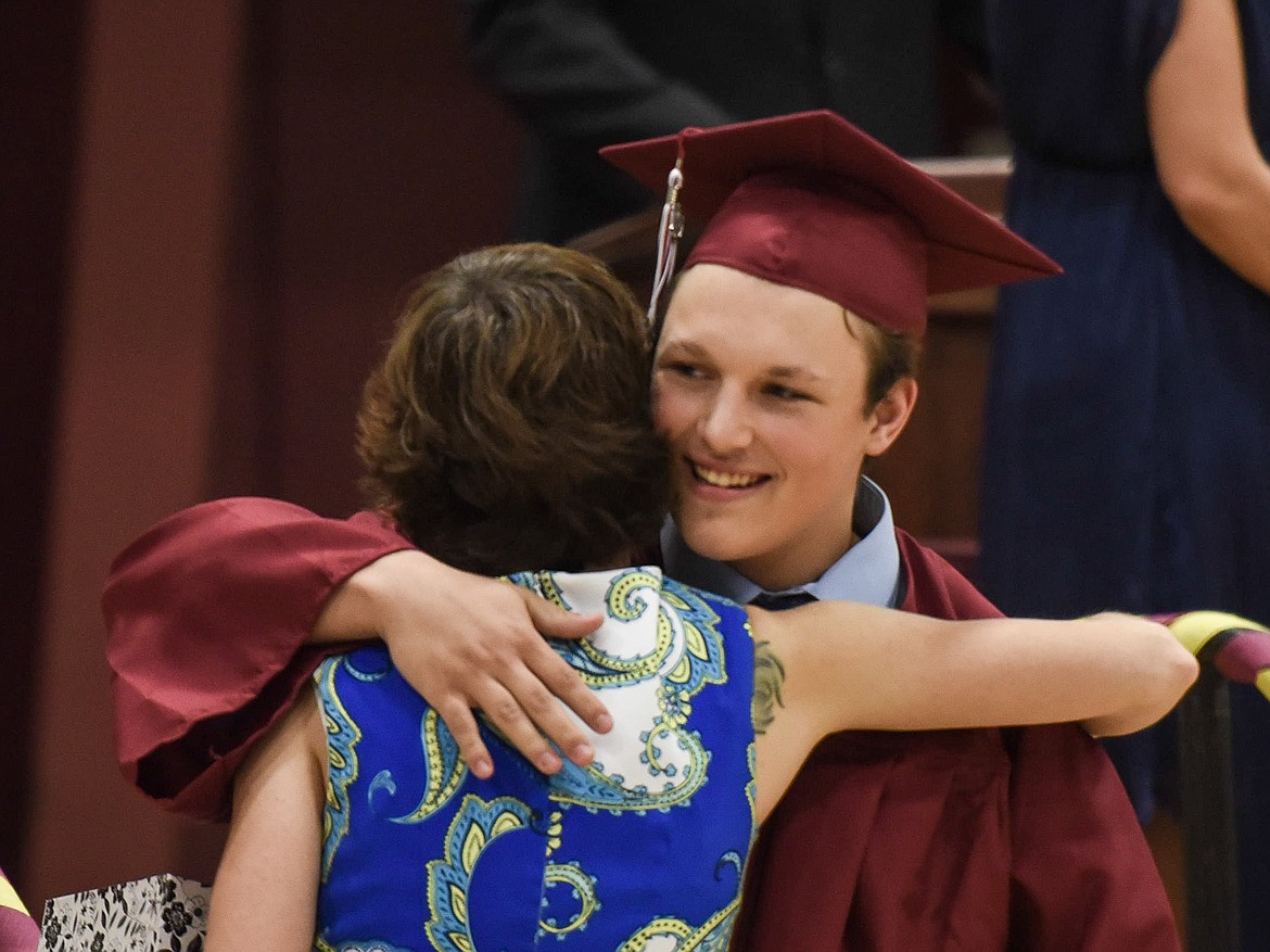 Troy High School&#146;s Logan Milde pauses to hug honorary speaker and Troy Spanish teacher Tabitha Maust after receiving his diploma, Saturday at Troy&#146;s graduation. (Ben Kibbey/The Western News)