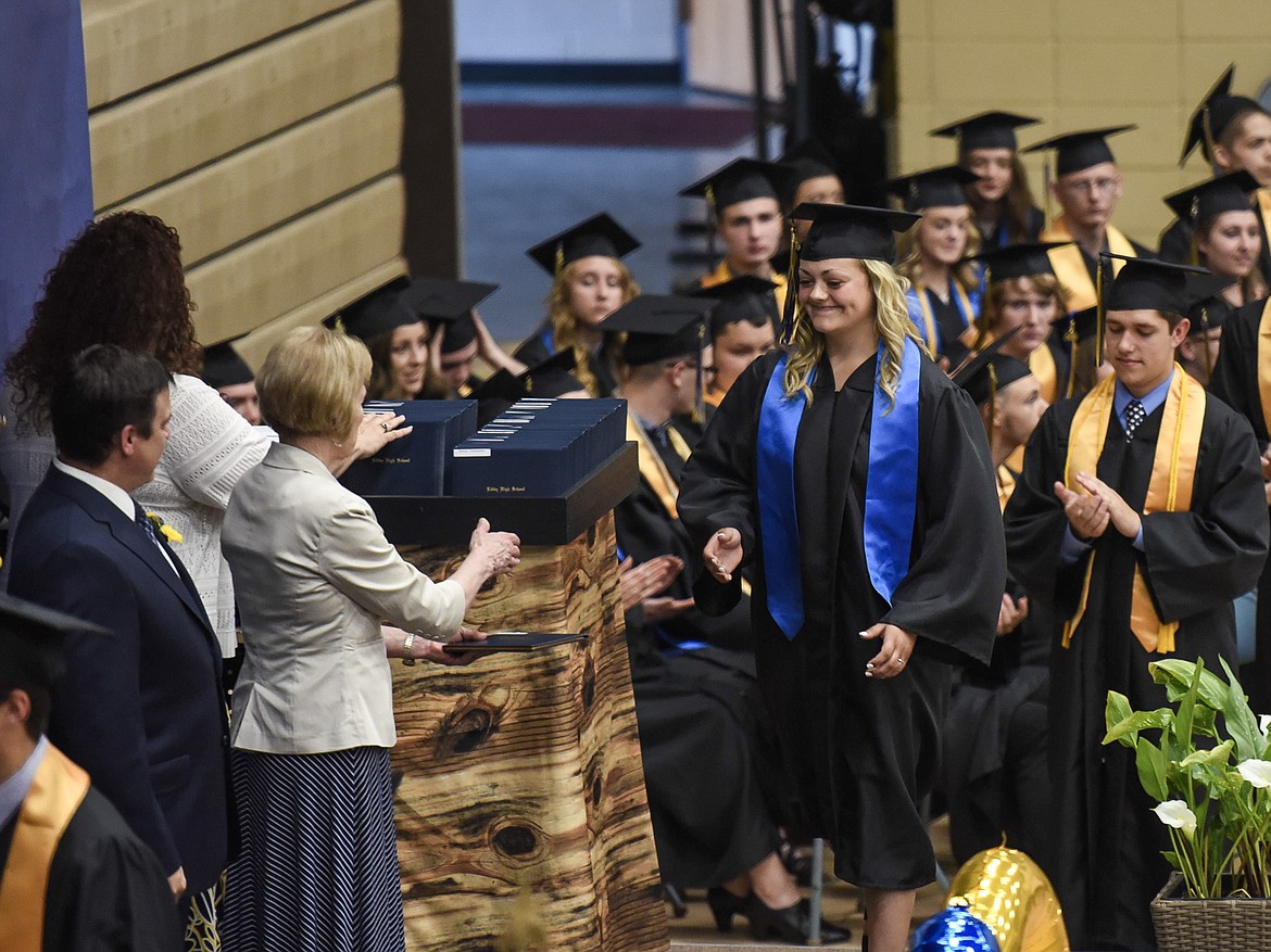 Libby High School&#146;s Emily Carvey walks onto stage to receive her diploma from Libby Public Schools Trustee Ellen Johnston, Saturday at Libby&#146;s graduation. (Ben Kibbey/The Western News)
