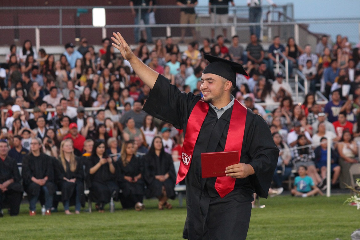 Cheryl Schweizer/Sun Tribune
Diploma in hand, a student in the class of 2019 waves to family and friends. Othello High School graduation was Friday.