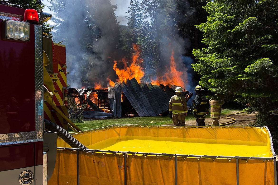 Photo by MIKE ELAM
Fire crews responded to this structure fire in north Bonner County last week. The fire on May 28 resulted in a total loss of the house. The house was in an area of &#147;no man&#146;s land,&#148; where the Northside and South Boundary fire departments, and Department of Lands had to come together to fight the blaze. &#147;Temperatures are hot, fuel is dry, and everyone be careful,&#148; said South Boundary Fire Department Chief Tony Rohrwasser.