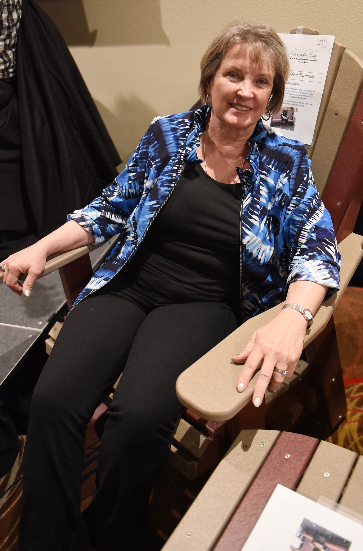 JANNA TAYLOR, a resident of Rollins, tries out the comfort of the outdoor furniture about to be auctioned during the On Eagle&#146;s Wings MVCA Benefit Auction.