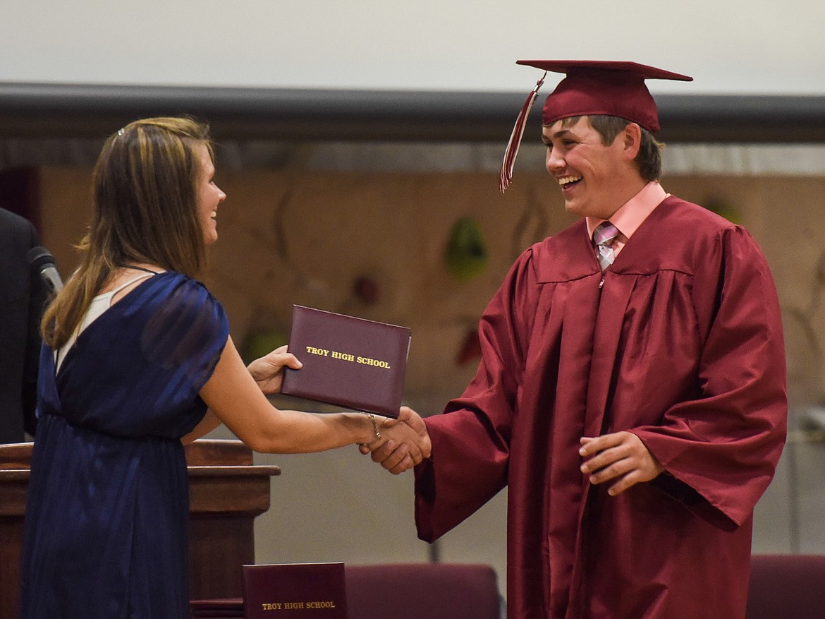 Austin McCully receives his diploma from Troy High School Principal Christina Schertel, Saturday at Troy&#146;s graduation at the Troy Activity Center. (Ben Kibbey/The Western News)