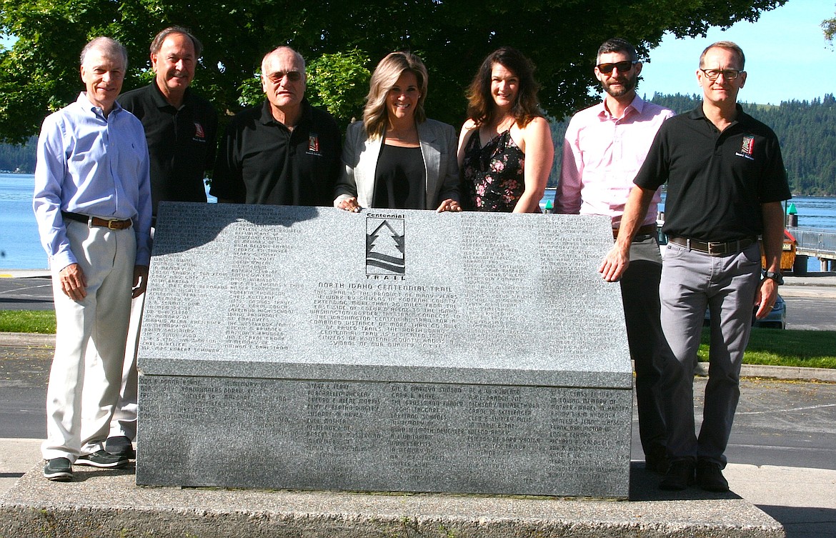 From left, North Idaho Centennial Trail Foundation board members Randy Haddock, Doug Eastwood, John Bruning, Executive Director Tabitha Kraack, Jennie Eggleston, Mike Schaffer and Tim Keaty stand next to the trail's monument at Independence Point in downtown Coeur d'Alene. The foundation on Tuesday unveiled findings of an economic impact study on the trail. (BRIAN WALKER/Press)