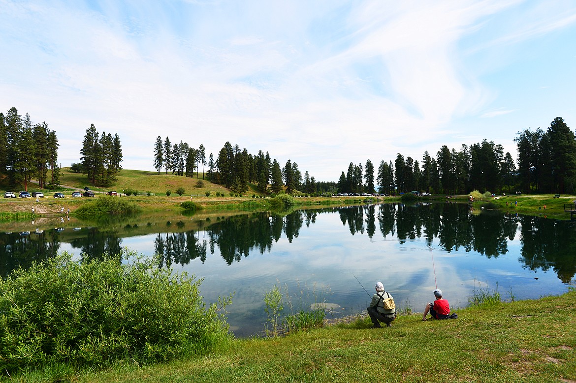 Jim Vashro, left, formerly of Montana Fish, Wildlife &amp; Parks and current president of Flathead Wildlife, fishes with Scott Schram, of Whitefish, during the Robin Street Memorial Family Fishing Day hosted by Montana Fish, Wildlife &amp; Parks at Pine Grove Pond in Kalispell on Saturday. (Casey Kreider/Daily Inter Lake)