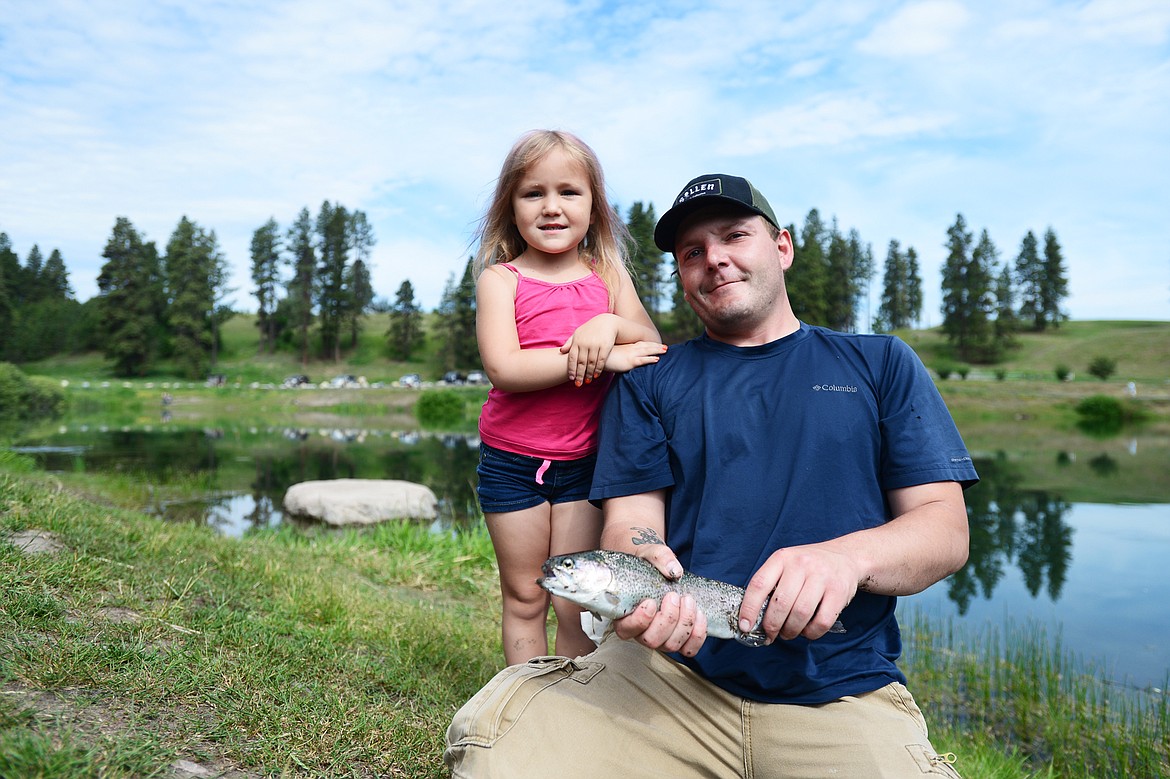 Derrick Downing and his daughter Denolly, 4, of Columbia Falls, hold a rainbow trout they caught during the Robin Street Memorial Family Fishing Day hosted by Montana Fish, Wildlife &amp; Parks at Pine Grove Pond in Kalispell on Saturday. They decided to release the fish back into the pond as they were primarily fishing for &quot;monsters.&quot; (Casey Kreider/Daily Inter Lake)