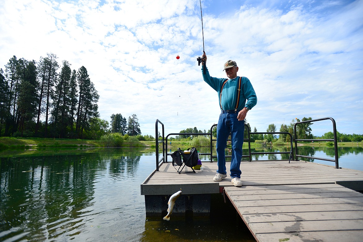 Jerry Quinn, of Kalispell, catches-then-releases a rainbow trout during the Robin Street Memorial Family Fishing Day hosted by Montana Fish, Wildlife &amp; Parks at Pine Grove Pond in Kalispell on Saturday. Quinn was fishing with his great granddaughter Channa Melnick. (Casey Kreider/Daily Inter Lake)