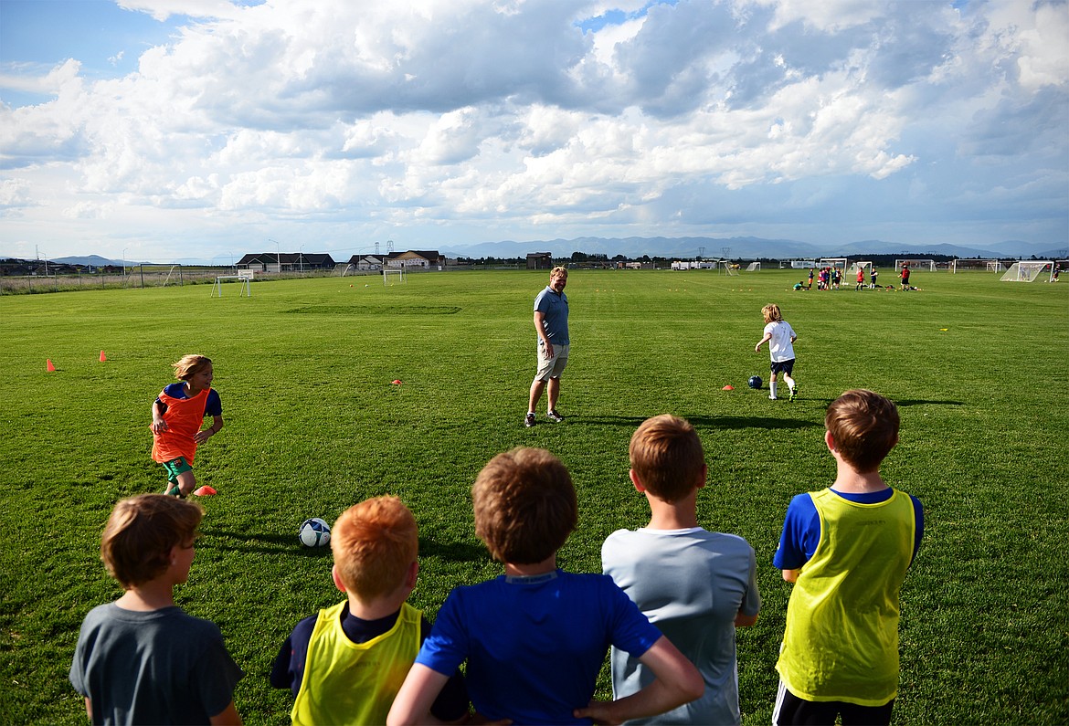 Flathead Force U11 boys' coach Scott Strobel, center, watches as half of his team plays a game called &quot;Catch Me If You Can&quot; during practice at Kidsports Complex on Thursday. (Casey Kreider/Daily Inter Lake)