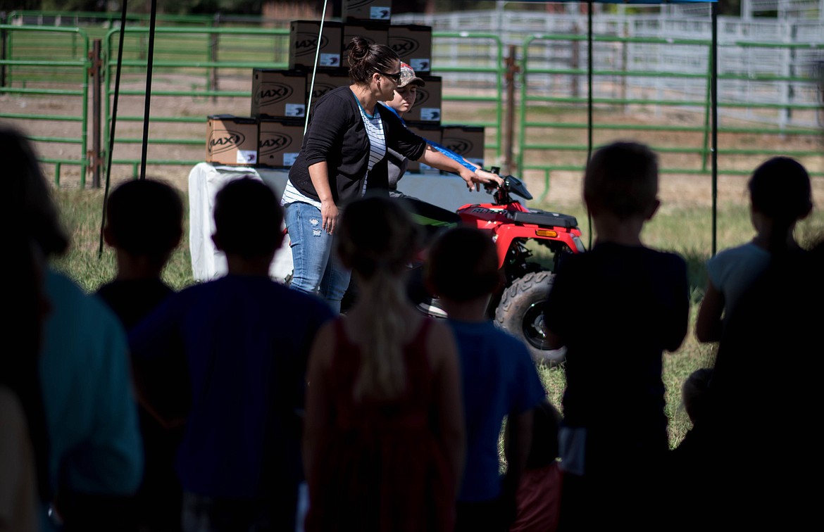 Children watch a safety demonstration on how to properly use a quad during a 4-wheeler training workshop for children at J. Neils Memorial Park, Tuesday. (Luke Hollister/The Western News)