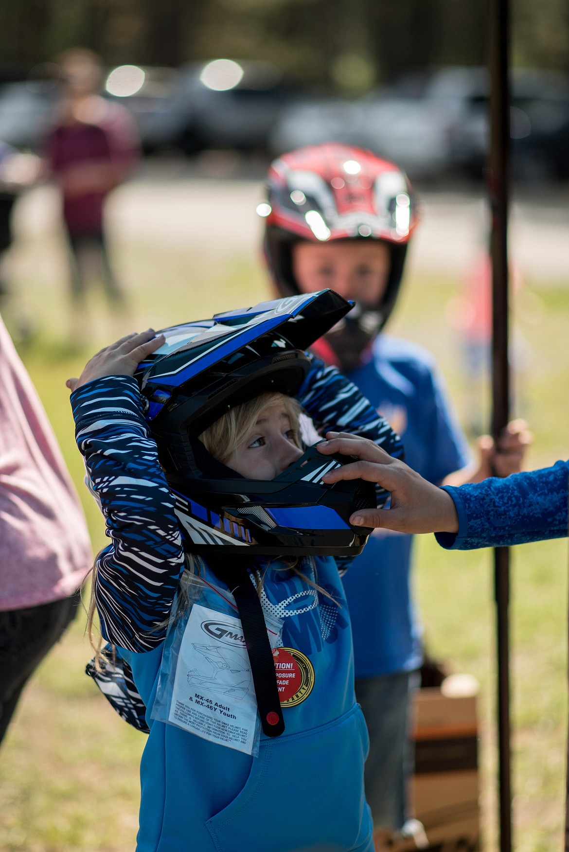 Mya Sloan tries out a new helmet during a 4-wheeler training workshop for children at J. Neils Memorial Park, Tuesday. (Luke Hollister/The Western News)