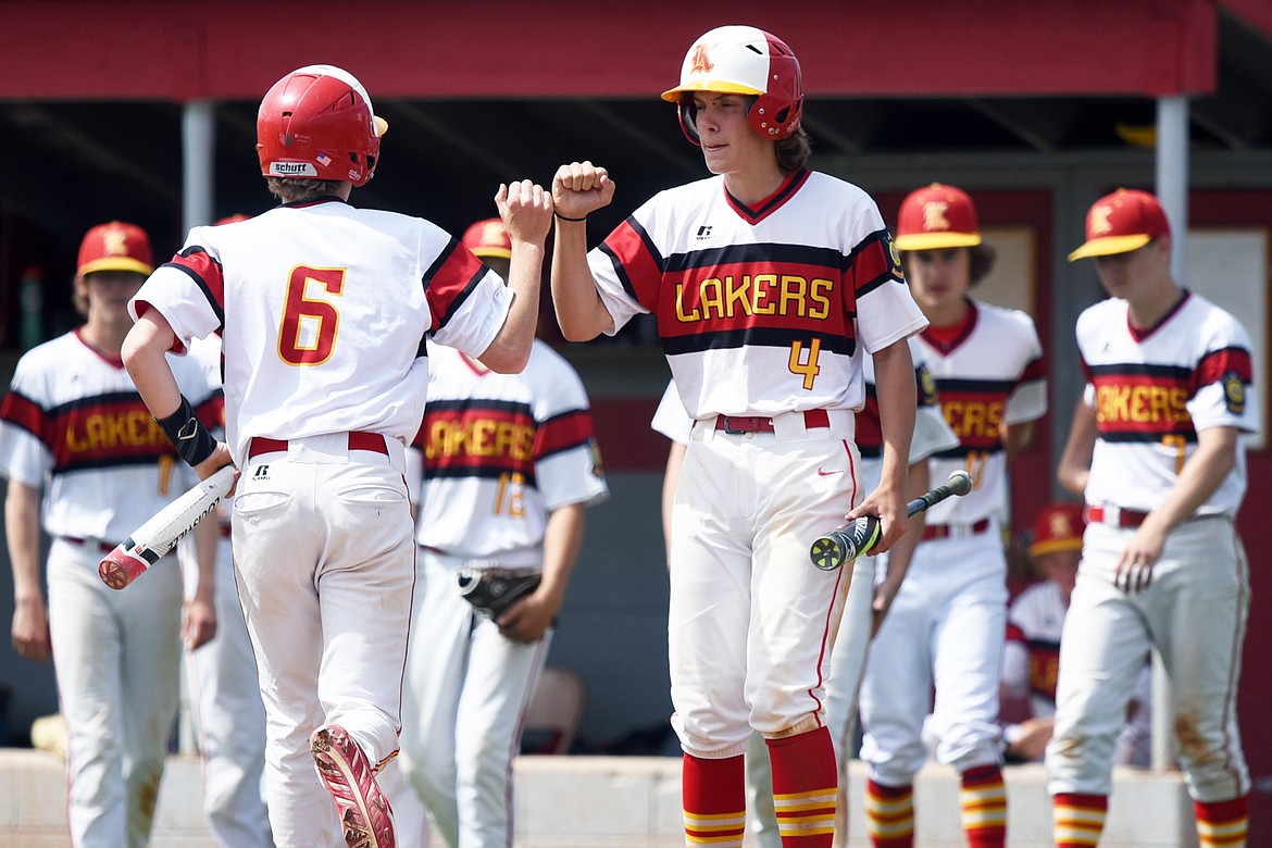 Kalispell's Grady Drish (6) bumps fists with Gage Brink (4) after scoring on Ben Corriveau's RBI single in the bottom of the second against the Cranbrook Bandits A at Griffin Field on Wednesday. (Casey Kreider/Daily Inter Lake)