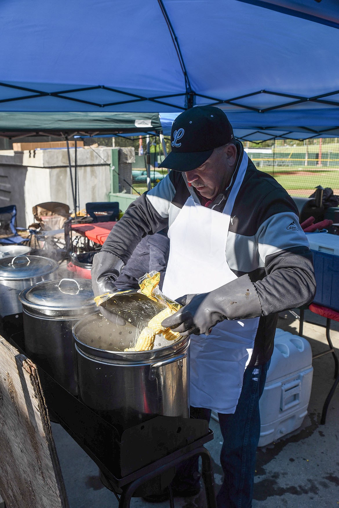 Jim Germany gets some more corn on the cob started during Dinner on the Diamond at Lee Gehring Memorial Field Friday.(Ben Kibbey/The Western News)