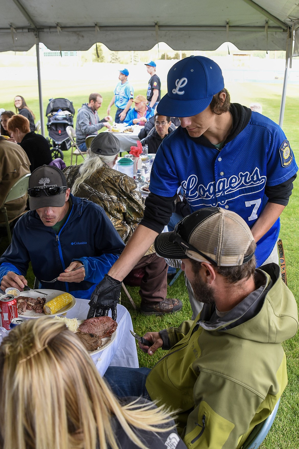 Libby Logger Moxley Roesler-Begalke serves up some seconds of prime rib during Dinner on the Diamond at Lee Gehring Memorial Field Friday. (Ben Kibbey/The Western News)