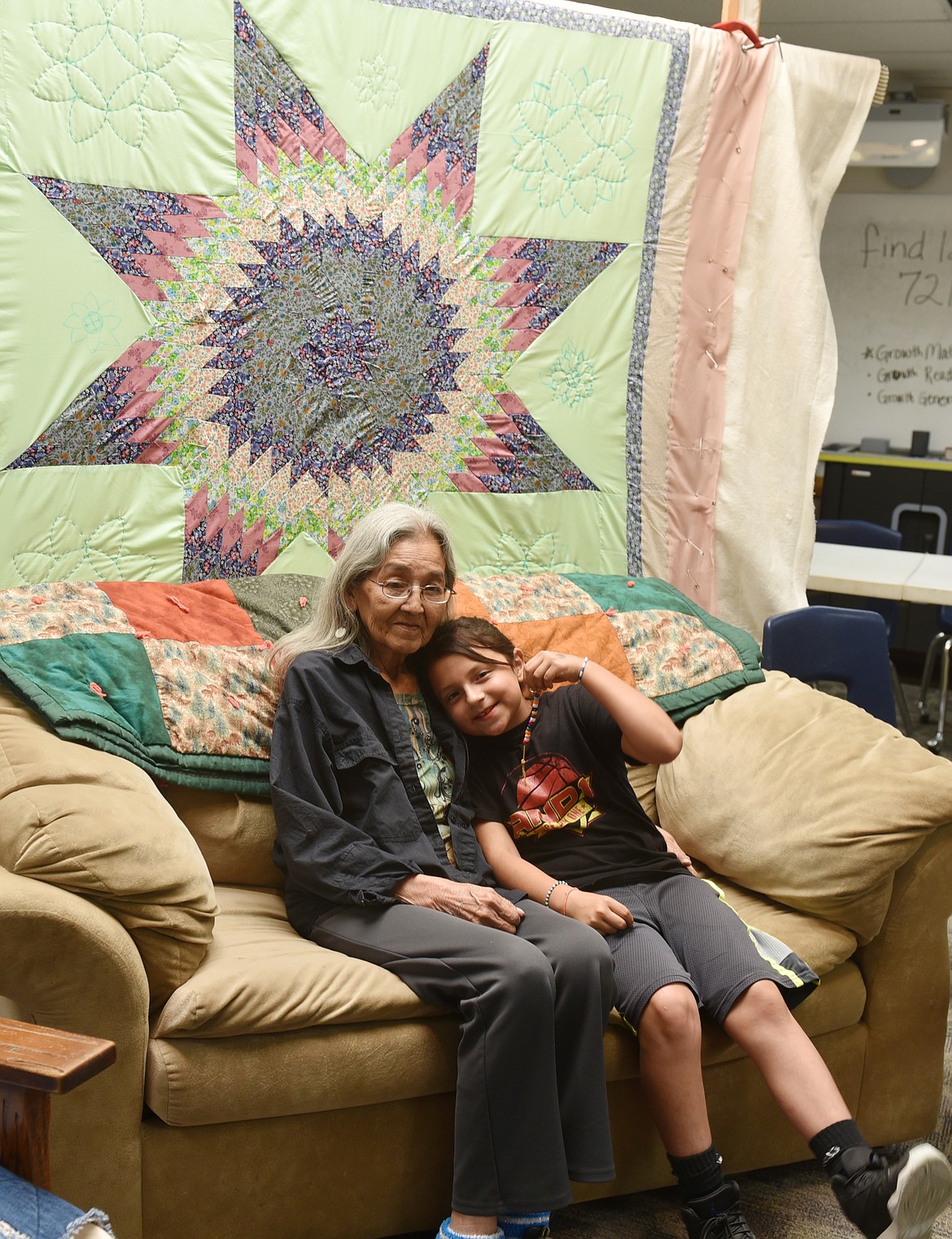 RITA ADAMS and Jayah Pierre shared the day. One of the Elder Olympics stations was this photo session, with a student-made quilt as the background. (Carolyn Hidy photos/Lake County Leader)