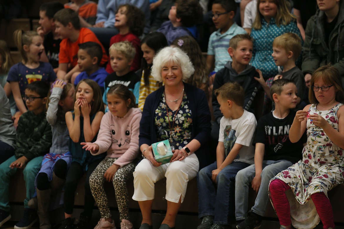 First-grade teacher Paula Hearn sits among her last class of students, with tissues on her lap in case of tears, during an assembly Thursday morning. (DEVIN WEEKS/Press)