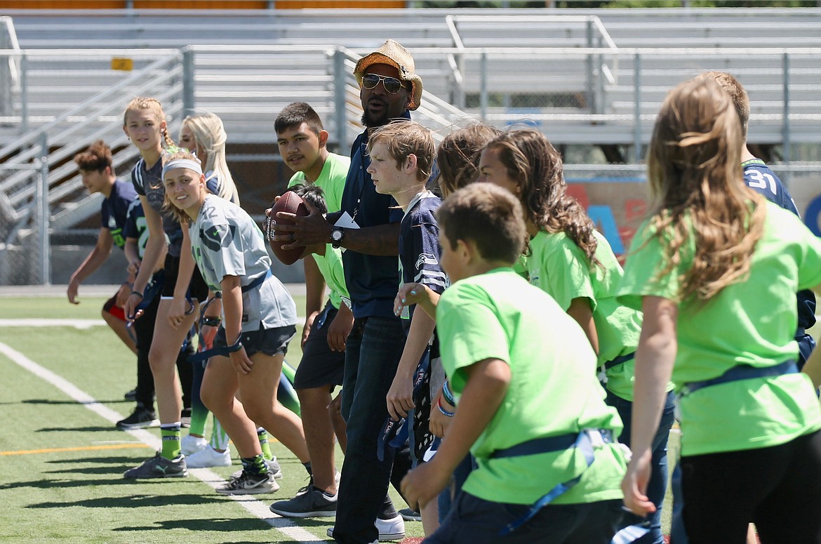 Casey McCarthy/ Columbia Basin Herald  Former Seahawk Jordan Babineaux hikes the ball with Frontier Middle School students at Lions Field on Friday in Moses Lake.