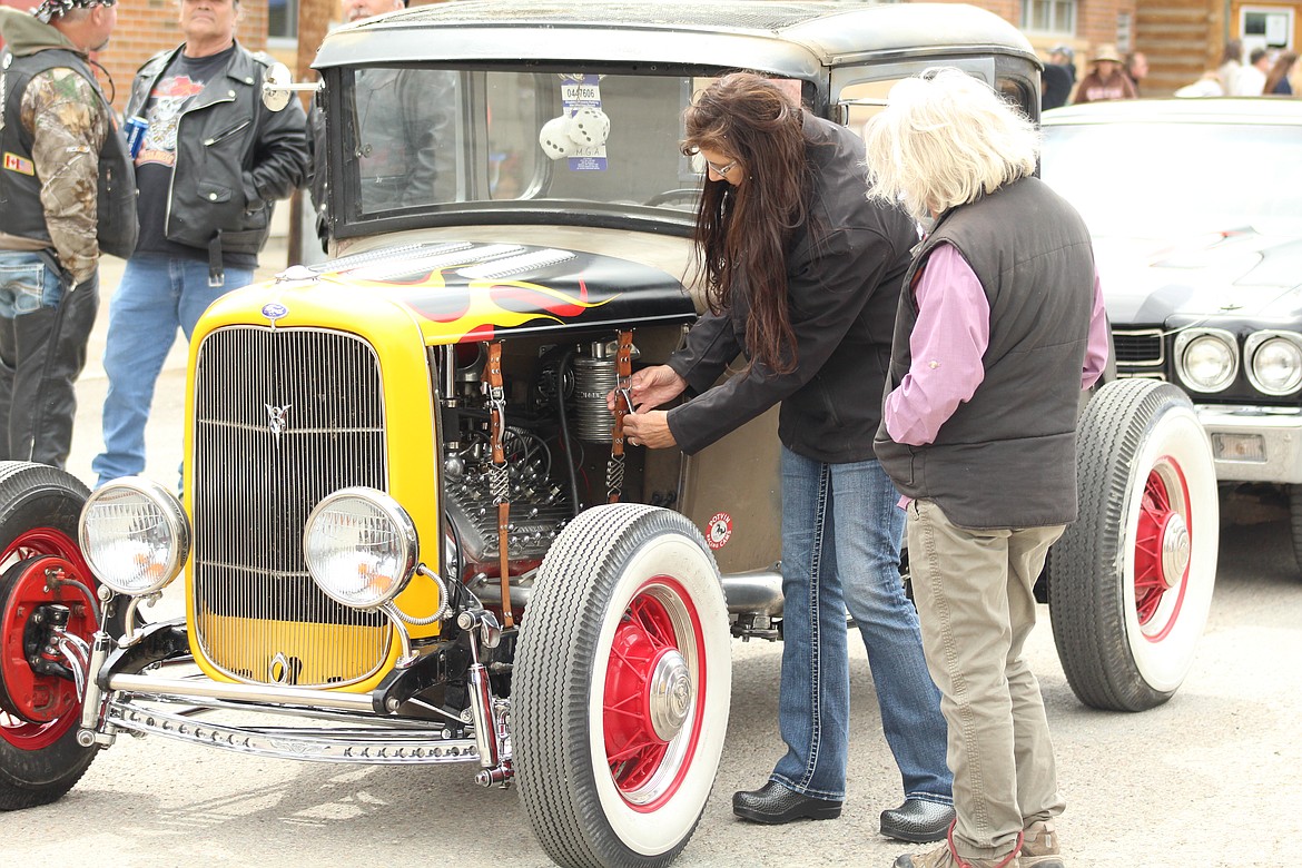 BARBARA GRANDON and Sandy Farrell looking at the Bonnet straps to a modified Model T at the Hot Springs Homesteader Days car show. (John Dowd/ Clark Fork Valley Press)