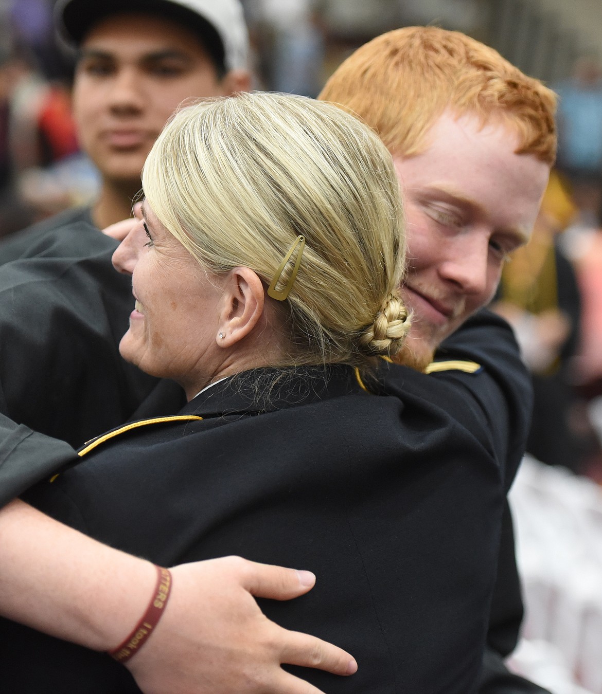 AARON HANSON gets an embrace from Montana Army National Guard SFC Tavia Moschetti after the commencement ceremony. Hanson, Kyla Blixt, Willy Lytton, Elliot Morigeau, Jerrica McCrea and Michael Yonkin are enlisting in the ANG.