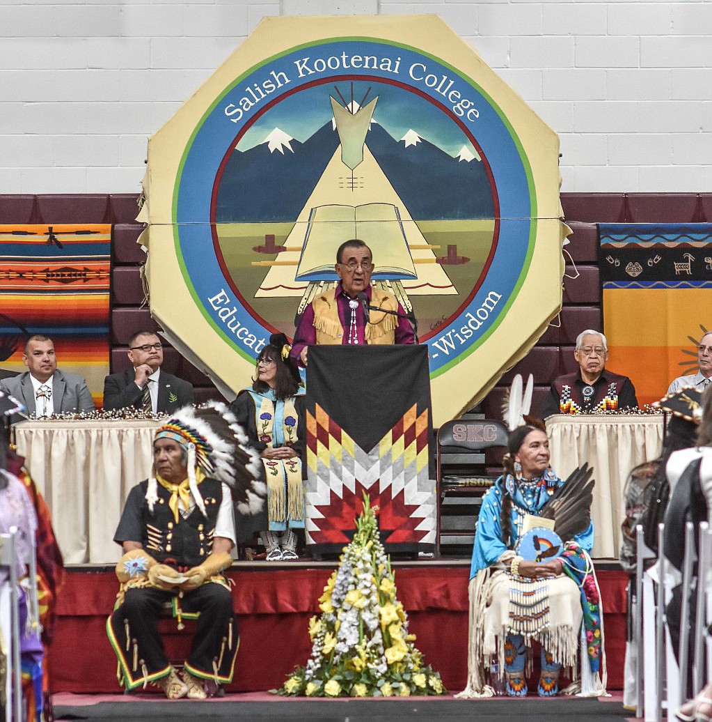 PROFESSOR EMERITUS and SKC founder Dr. Joseph McDonald gives the 2019 Commencement Address. In front, Wilbert Michel, Sr. and Linda King, SKC Head Male and Female War Dancers, led off the ceremonies. (Photos courtesy of Christa Umphrey/SKC)