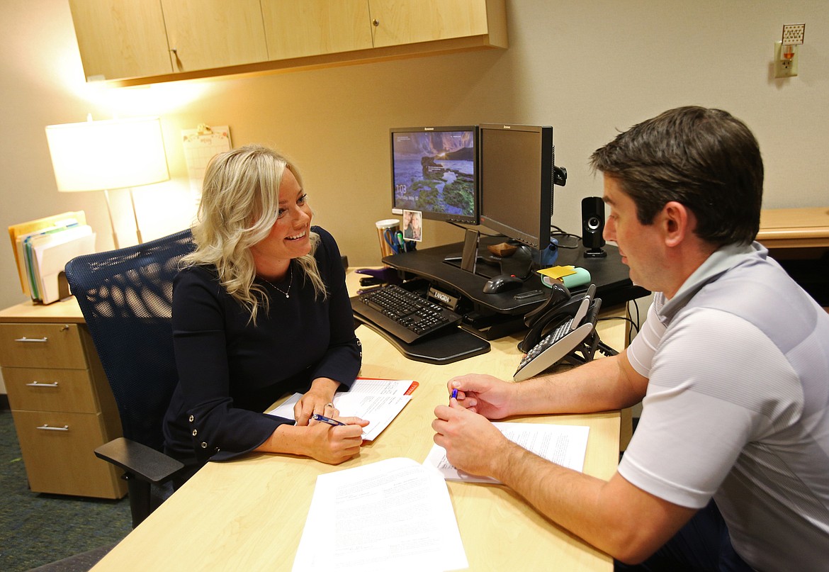 Brianna Robson, director of Human Resources at The Resort, helps Whispers Manager Jake Hill fill out paperwork.