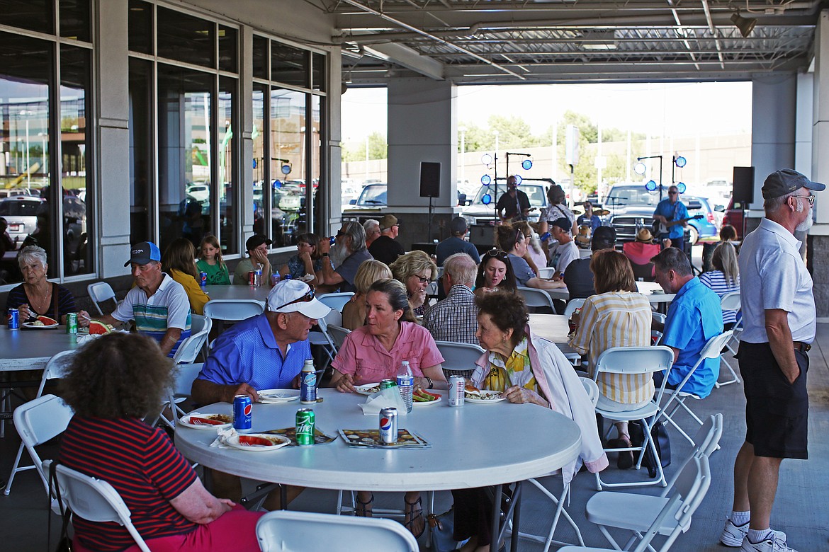 Attendees mix and mingle as they listen to music and munch on food at Knudtsen Chevrolet&#146;s 80th anniversary celebration.