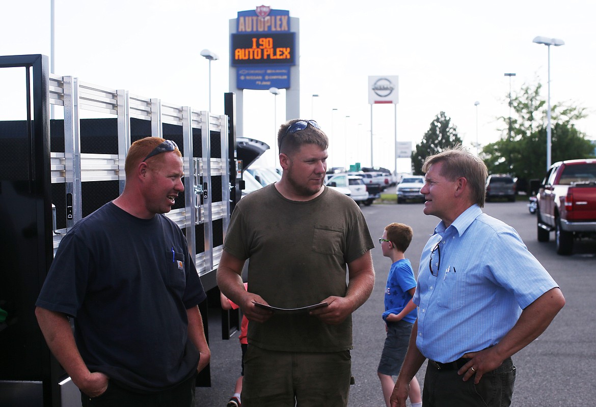 Mike Chapman, left, Jace Witcher, middle, and car salesman Brad Shafer talk about the specs of a Silverado 6500 Heavy Duty at Knudtsen Chevy&#146;s 80th anniversary celebration.
Photo by
LOREN BENOIT