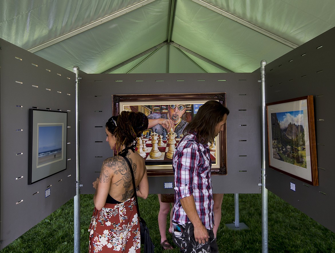 Amy Ableman-Zimmerman and Johnathan Klemm look at art at the Juried Art Show tent at Art on the Green in 2017

LOREN BENOIT/Press File