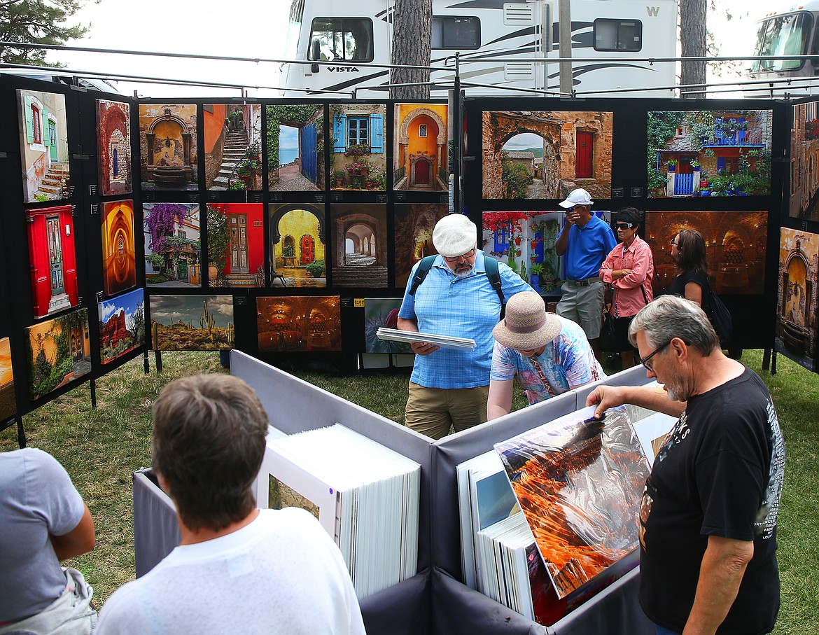 Attendees browse through Siep Buenker's photographs, Friday, at Art on the Green at North Idaho College in 2018.(LOREN BENOIT/Press File)