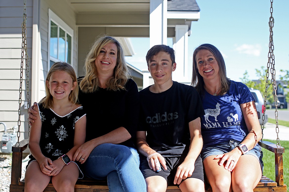 From left, Reese Wilson, 8, Katie Wilson, Brendan Wilson, 14, and Katie's sister Elaina Matthews pose for a family photo on the porch of their Coeur d'Alene Home on Wednesday. Katie Wilson, a North Idaho College psychology instructor and a former mental health therapist, said that she and her support group hope people will consider donating to the Ocular Melanoma Foundation to help fight cancer. (LOREN BENOIT/Press)