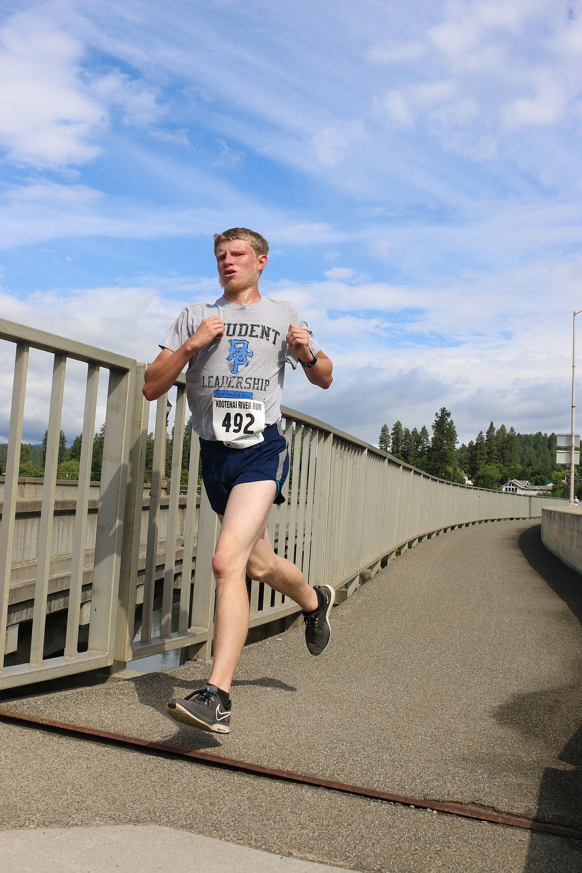 Photos by MANDI BATEMAN
Samuel Gorton powers toward home across the Kootenai River bridge, en route to a first-place finish in the 5K Men&#146;s 16-19 age group.