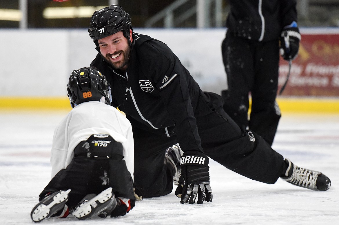 Courtney Ports, manager of hockey development with the Los Angeles Kings, shares a laugh with Vinni Ferruzzi, 6, of Missoula, at the L.A. Kings Summer Camp-Whitefish at Stumptown Ice Den in Whitefish on Thursday. (Casey Kreider/Daily Inter Lake)