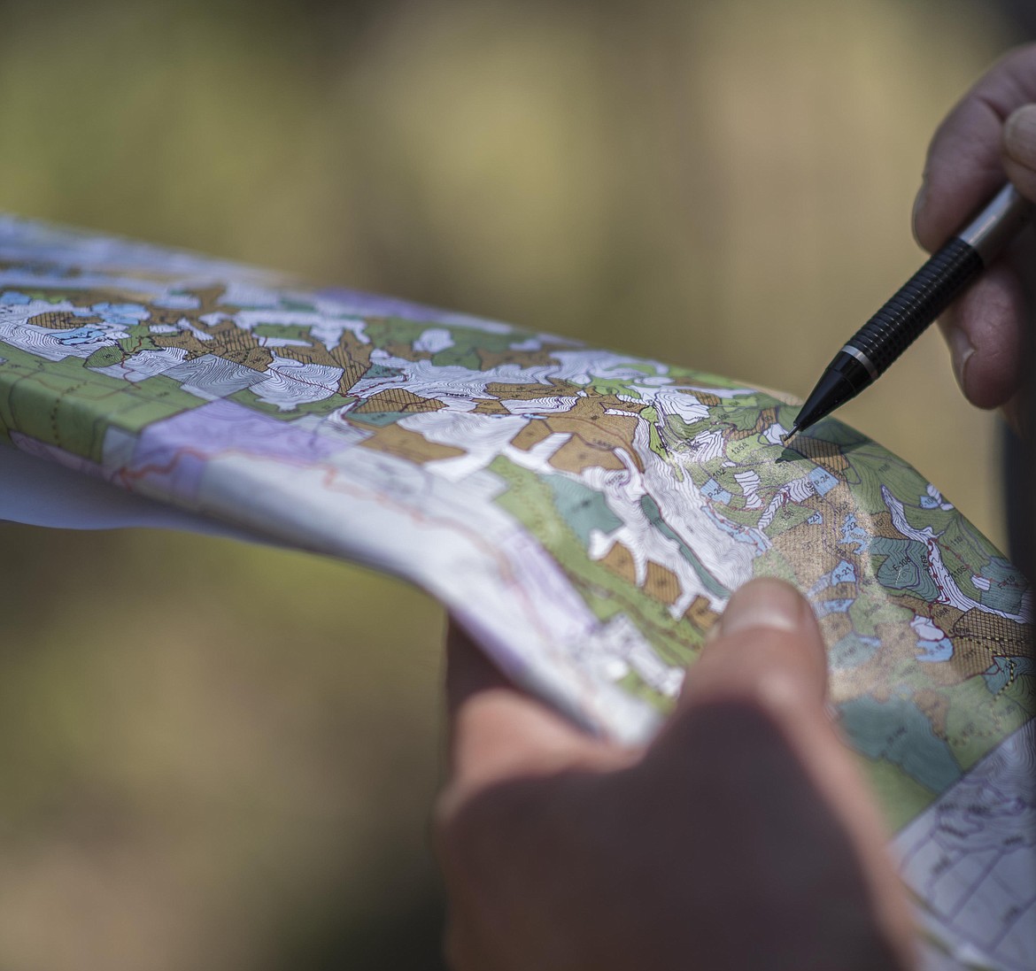 An attendees of a U.S. Forest Service led field trip through the Ripley Project area looks over a map of the proposed conservation easement. (Luke Hollister/The Western News)