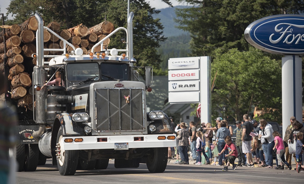 Logging trucks head down Mineral Avenue during the Libby Logger Days parade Saturday morning. (Luke Hollister/The Western News)