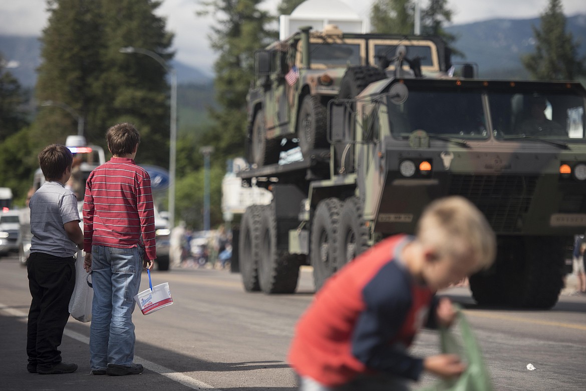 Children watch a National Guard truck from Detachment 1, 639th Quartermaster, as it drives past them during the Libby Logger Days parade Saturday morning. (Luke Hollister/The Western News)
