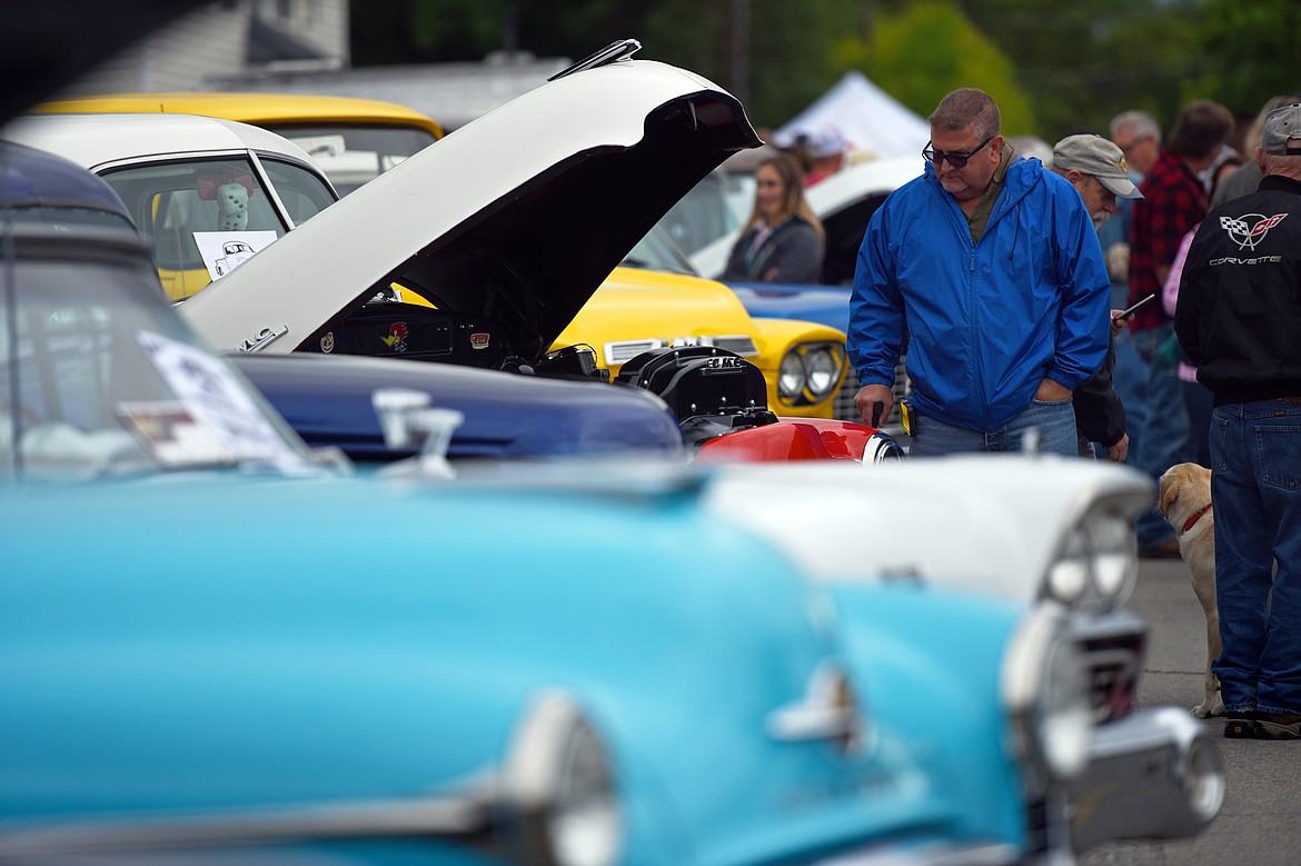 Visitors check out rows of custom, classic and unfinished cars at The Big Shindig outside The DeSoto Grill in Kalispell on Saturday. The Big Shindig features a wide range of cars as well as live music, barbeque, beer and a pin-up polar plunge. (Casey Kreider/Daily Inter Lake)