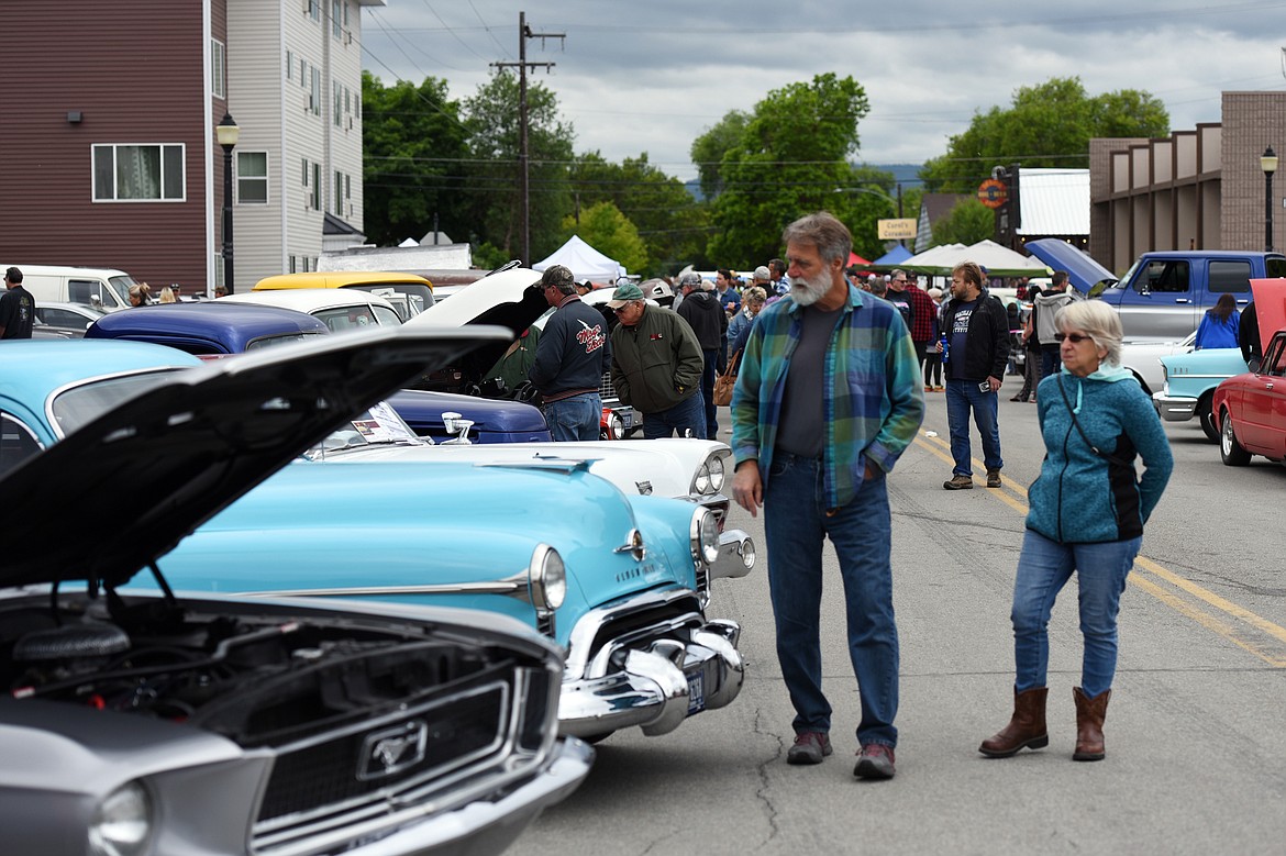 Visitors check out rows of custom, classic and unfinished cars at The Big Shindig outside The DeSoto Grill in Kalispell on Saturday. The Big Shindig features a wide range of cars as well as live music, barbeque, beer and a pin-up polar plunge. (Casey Kreider/Daily Inter Lake)