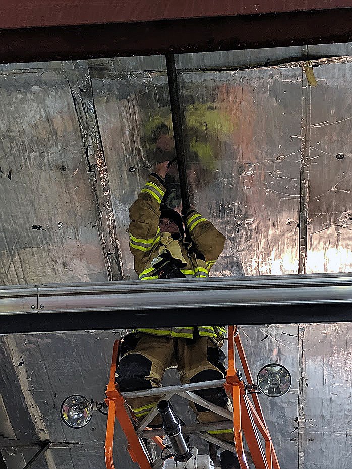 Moses Lake Fire Department/courtesy photo
Probationary firefighter Lynn Falconer works to replace one of two fire sprinkler heads that fused and contained the fire.